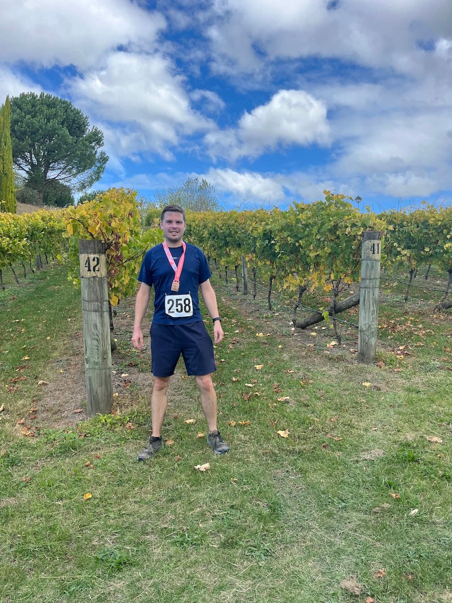 Picture with medal in front of vineyard